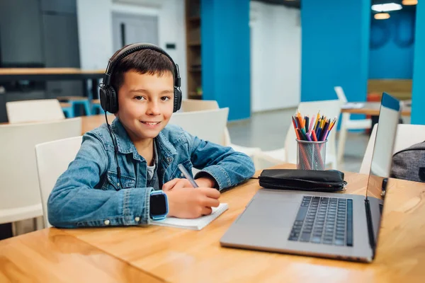 Niño Concentrado Niño Con Portátil Haciendo Tarea Con Auriculares — Foto de Stock