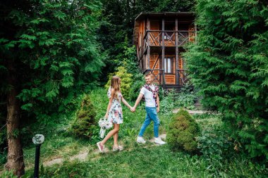 Evin yanında yürüyen güzel bir çiftin fotoğrafı, güzel bir yaz günü..