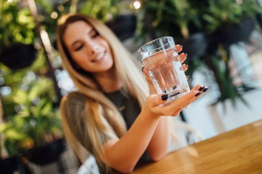 Güzel genç kadın mutfakta su ile.