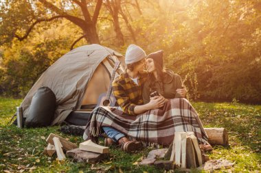Genç ve sevgi dolu iki turist ateşin yanında dinleniyor.