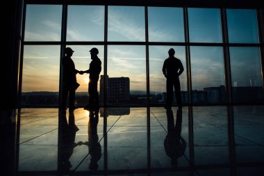 Mühendislerin ya da tasarımcıların panorama penceresine, arka plan fotoğrafına, gün batımına baktığı.