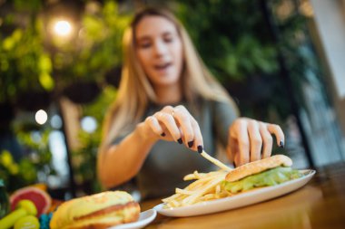 Close up photo, woman have a dinner with burger and fries. clipart