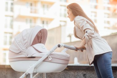 Aile, çocuk ve ebeveyn kavramı - mutlu anne ile bebek arabası park.