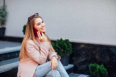 Güzel bir kızın fotoğrafı zamanını sokakta geçirir ve telefonuyla konuşur..