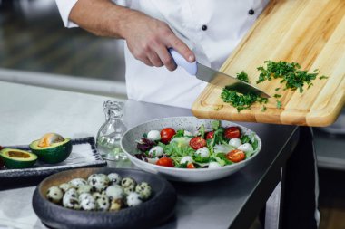 Aşçı, sebze kesme ve salata hazırlama. Sadece eller. Nihayet bulaşık sosu. Fotoğrafı kapat. Sağlıklı ve taze gıda konsepti.