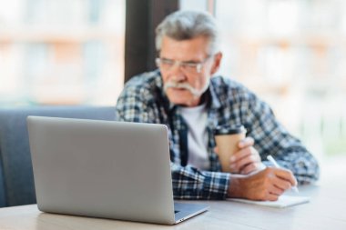 Laptopa odaklan, yaşlı adam kafede bilgisayar başında çalışıyor kahve içiyor, yaşam tarzı kavramı..