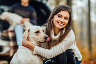 Parkta altın toplayıcı Labrador 'una sarılan güzel genç bir kadın..