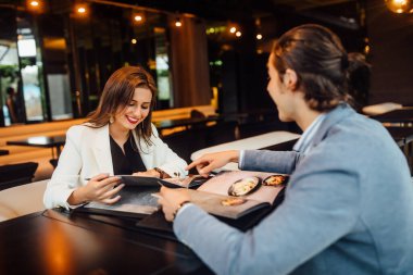 Lokantada menüleri olan neşeli bir çift menüye bakıyor..