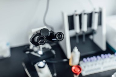 Çoklu lensli güçlü bir bilimsel laboratuvar mikroskobu. Biyoteknoloji donanım donanımı, beyaz klinik. Enstrüman konsepti. Kan testi, şeker kutusu..