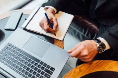 Çalışan adam evrak ve dizüstü bilgisayar üzerinde çalışıyor. İş ve teknoloji kavramı.