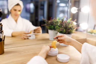 Genç kız cilt bakımı için bant tutuyor..