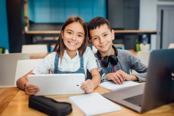 Dos Pequeños Amigos Felices Escribiendo Tareas Usando Tableta Digital Inteligente —  Fotos de Stock