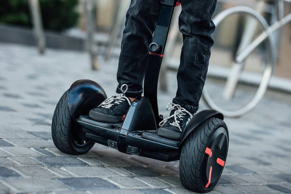 Man legs riding electric hoverboard in park. Close up leg photo.