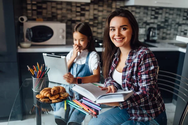 Mamá Ayuda Hija Hacer Tarea Con Libro Las Manos Cocina — Foto de Stock