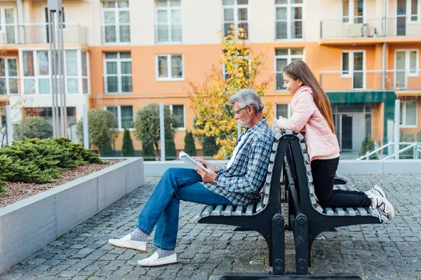 Linda Niña Relajándose Con Abuelo Banco Hombre Leyendo Libro — Foto de Stock