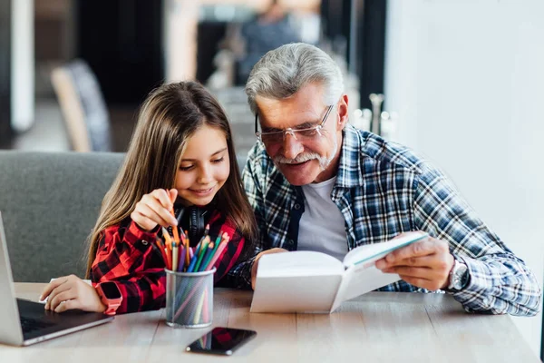 Großvater Mit Bart Unterrichtet Enkelin Zeichnen Mit Laptop Und Hausaufgaben — Stockfoto