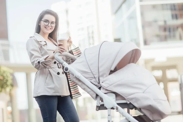 Herrliche Mutter Mit Kinderwagen Geht Durch Und Hält Einkaufstüten Kaffee — Stockfoto