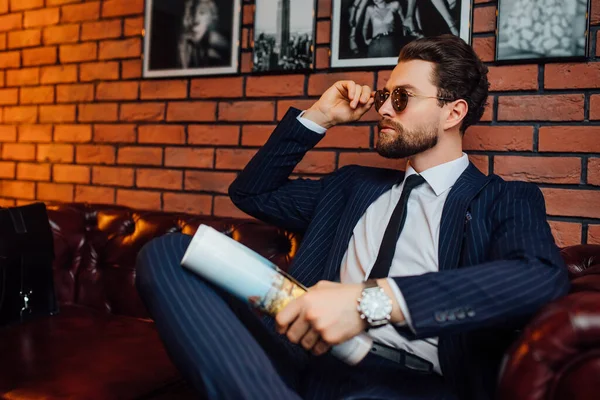 Modny Model Lub Biznesmen Odpoczywający Trzymający Okulary Magazynem Luksusowym Apartamencie — Zdjęcie stockowe