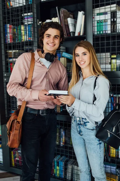 Joyeux Jeune Couple Dans Bibliothèque Tenant Livre — Photo