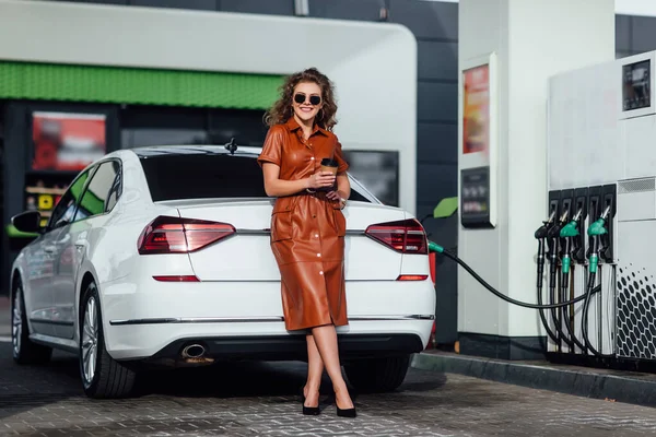 Çekici Genç Kadını Bir Benzin Istasyonunda Arabasına Yakıt Doldururken Bir — Stok fotoğraf