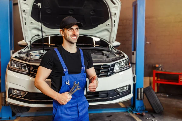 Mechanik Odzieży Roboczej Trzymający Klucze Pokazujący Kciuk Górę Warsztacie — Zdjęcie stockowe