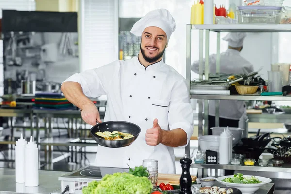 若い髭と成功した笑顔の男性 キッチンで食べ物を飾る料理人 大丈夫サイン — ストック写真