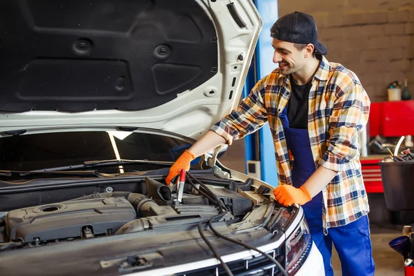 Auto Τεχνικός Ομοιόμορφη Και Καπάκι Φόρτισης Της Μπαταρίας Χρησιμοποιώντας Καλώδια — Φωτογραφία Αρχείου