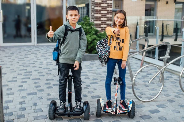 Δύο Παιδιά Μαθαίνουν Οδηγούν Hoverboard Σακίδιο Ένα Πάρκο Την Ηλιόλουστη — Φωτογραφία Αρχείου