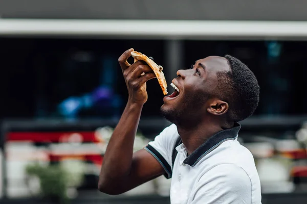 Young Man Eats Piece Appetizing Pizza Hungry Guy Holds Piece — Stock Photo, Image