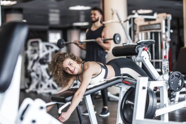 Very sexy young beautiful woman training and doing exercise for ass in thong at the gym club.
