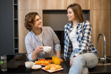 Genç, evli bir çift mutfakta kahvaltı yaparken eğleniyor..