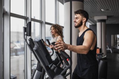 Siyah spor salonunda kadın ve erkek aerobik egzersizi yapıyor..