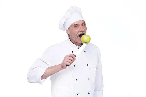 白い背景に滞在しながら 緑のリンゴと均一な保持金属ナイフの老人 プロのシェフ — ストック写真