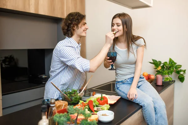 Young Couple Modern Kitchen Woman Holding Wine Glass Male Feeding — Stock Photo, Image