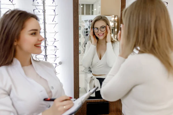 Optician Está Ajudando Cliente Feminino Escolher Óculos Óptica Mulher Tentando — Fotografia de Stock