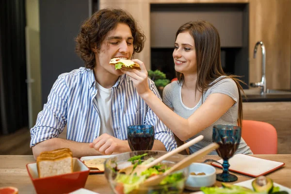 Jovem Casal Feliz Cozinha Moderna Mulher Segurando Sanduíche Alimentação Masculina — Fotografia de Stock