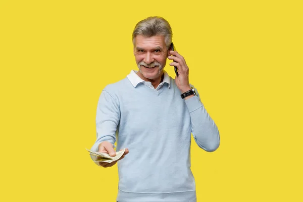 Buon Uomo Anziano Con Soldi Contanti Telefono Sfondo Giallo Spazio — Foto Stock