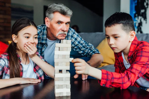 Lustiger Großvater Spielt Mit Tochter Und Sohn Ein Holzturmspiel — Stockfoto