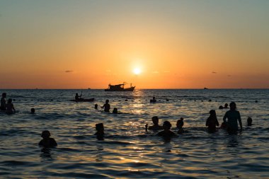 Phu Quoc adasında insanların siluetleriyle sahilde güzel bir gün batımı..