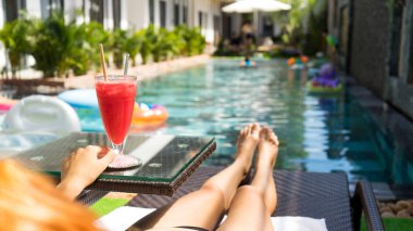 Yaz tatili tarzı kızıl saçlı güzel bir kadın tatillerde havuz kenarında karpuz suyu tutuyor. Seyahat konsepti..