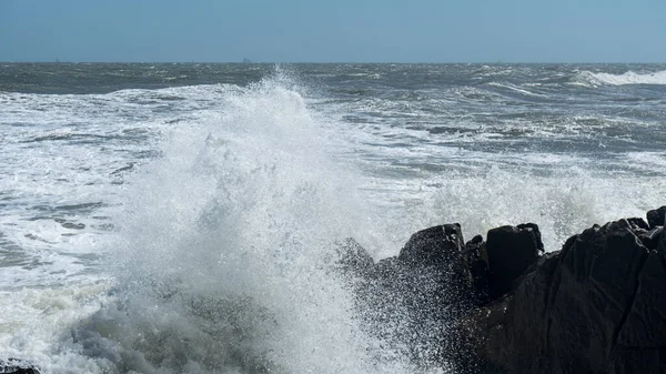 Sea foam waves crash on the rocks.Waves with  sea foam break background