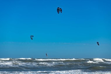 Uçurtma sörfçüsü denizin altında uçuyor. Vietnam 'da aynı anda hem sörf hem de paraşütle atlayan biri..