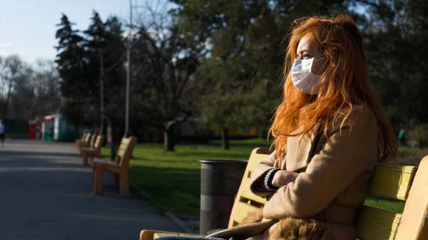 Traurige Schöne Rothaarige Mädchen Sitzt Leeren Park Mit Chirurgenmaske Wegen — Stockfoto