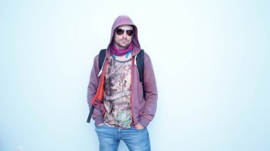 Kulaklıklı, güneş gözlüklü, duygusal komik adam. Kapüşonlu, mutlu ve yüzünde gülümseme olan genç bir adamın portresi..