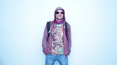 Kulaklıklı, güneş gözlüklü, duygusal komik adam. Kapüşonlu, mutlu ve yüzünde gülümseme olan genç bir adamın portresi..