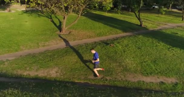 Vídeo Aéreo Del Hombre Caucásico Corriendo Soleado Parque Público Verde — Vídeos de Stock