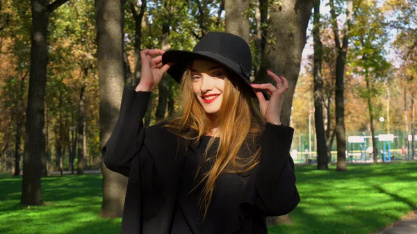 Jonge vrouw met rode lippen in stijlvolle jas en hoed — Stockfoto