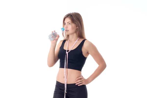 Ragazza atletica in possesso di una bottiglia e andando a bere un po 'd'acqua — Foto Stock