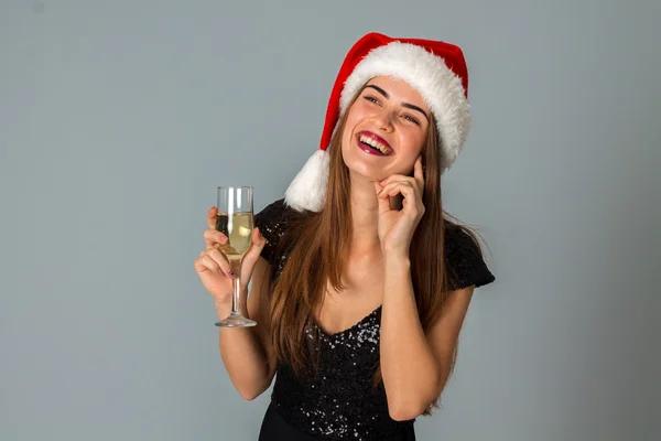 Bella ragazza in cappello di Babbo Natale con bicchiere di champagne — Foto Stock