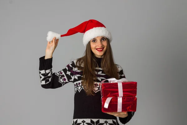 女人在温暖的毛衣和圣诞老人帽子红色礼物 — 图库照片